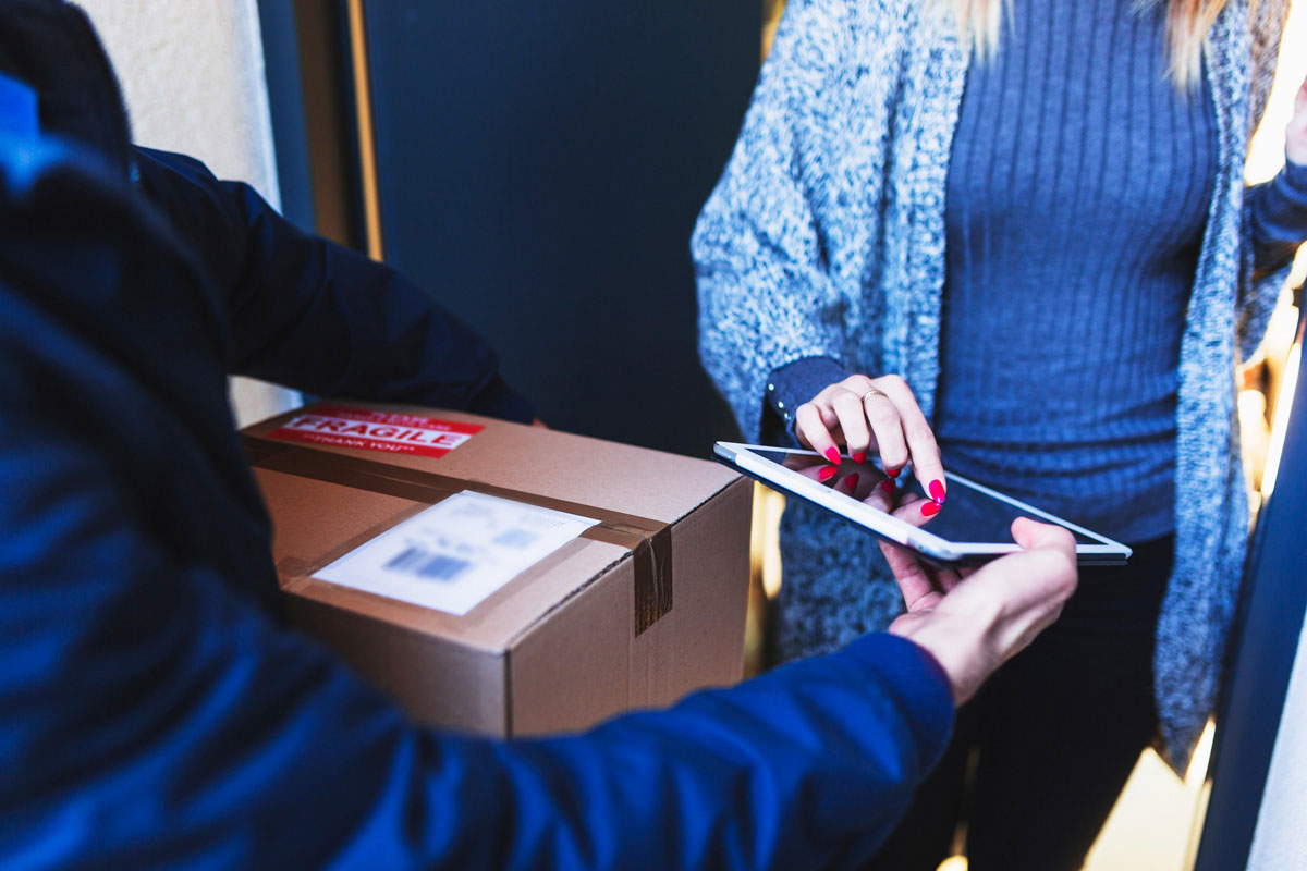 a courier service provider delivering a parcel to a client, tracking parcel, track shipments and check shipment delivery status online.